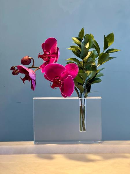 ARRANJO FLORAL COM ORQUÍDEAS EM VASO DE ACRÍLICO.