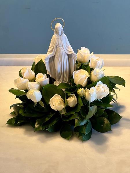 IMAGEM DE NOSSA SENHORA EM GESSO COM ARRANJO DE FOLHAGENS.